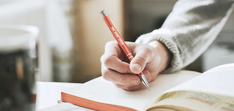 ragazzo che scrive con una penna personalizzata