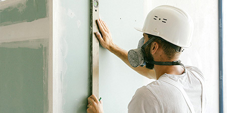 Lavoratore con DPI completi in cantiere: maschera filtrante e casco protettivo