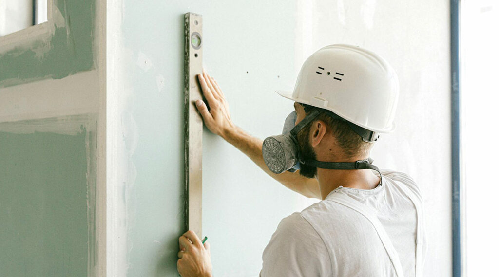 Lavoratore con DPI completi in cantiere: maschera filtrante e casco protettivo