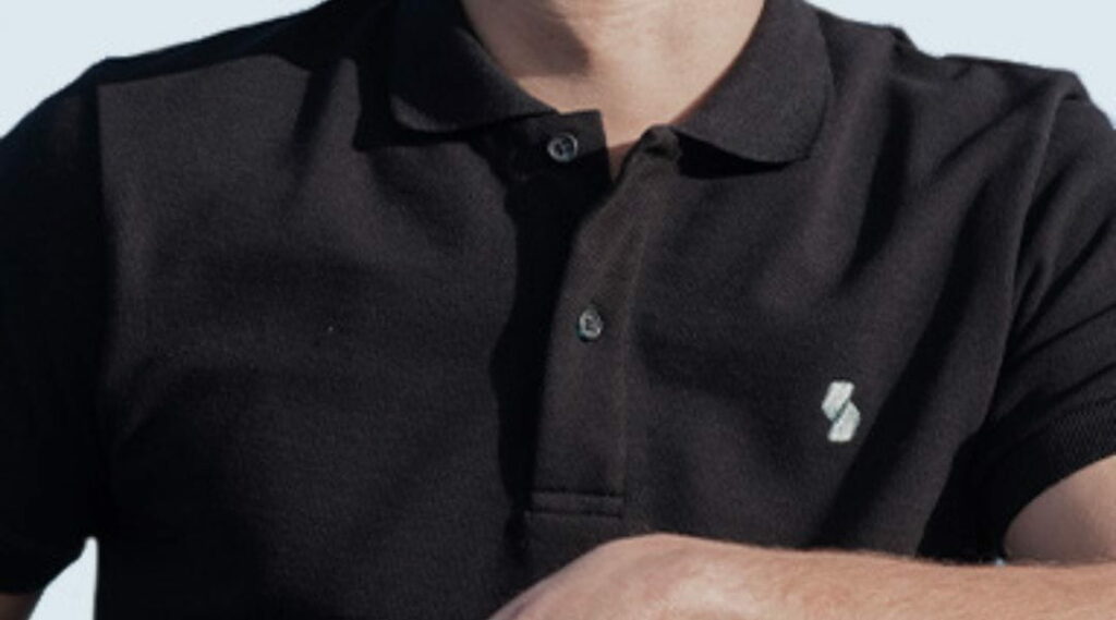 Uomo indossa polo nera con logo aziendale