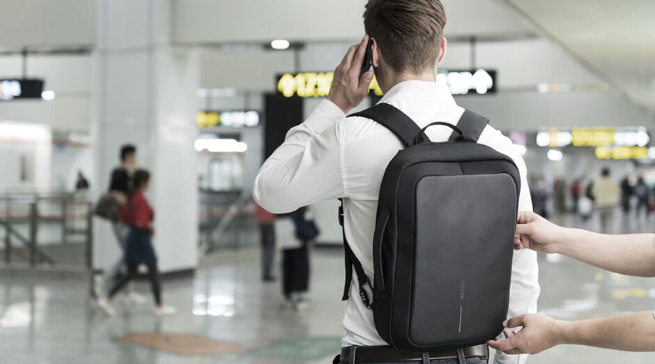 Uomo di spalle con zaino in aeroporto