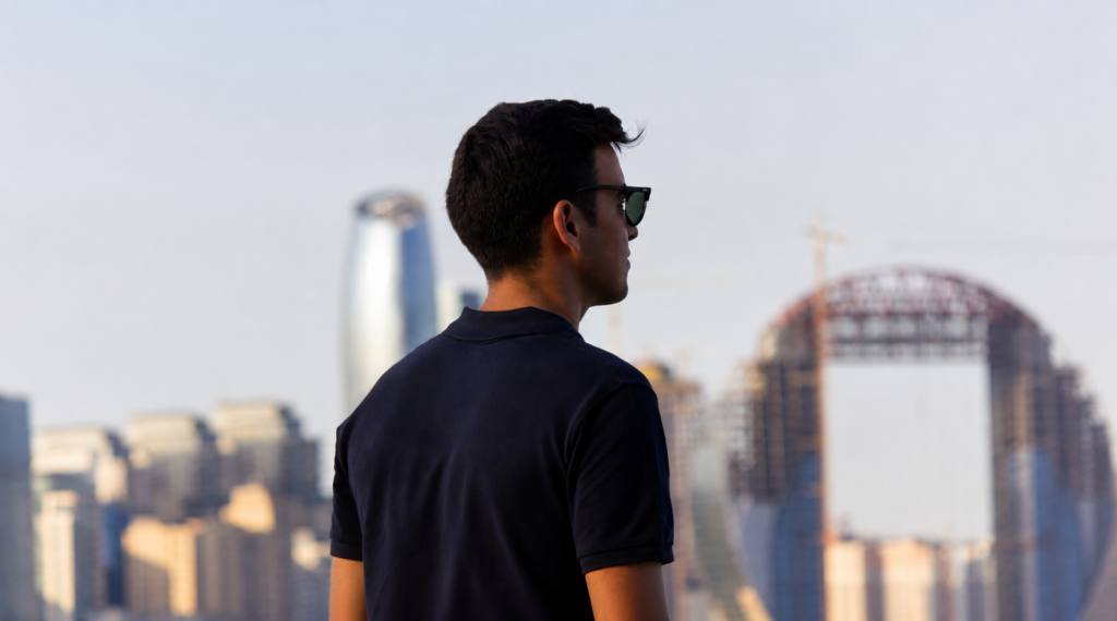 Uomo di spalle che indossa una polo nera in un ambiente urbano