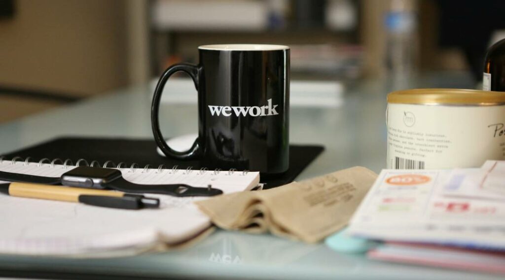 Tazza aziendale nera personalizzata con scritta "We Work" stampata