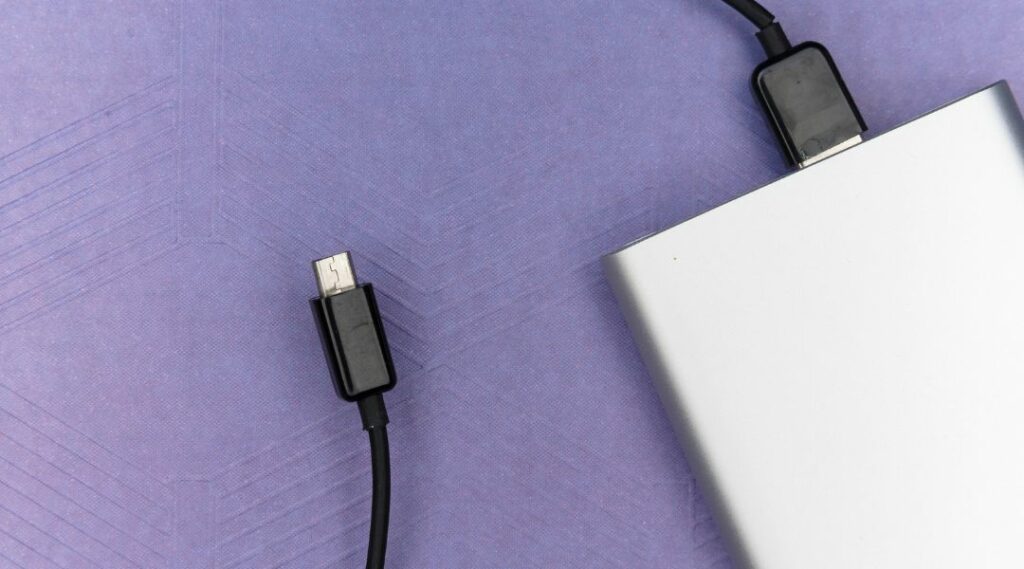 Power bank grigio metallizzato collegato a un cavo nero