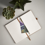Taccuino A5 in pelle sintetica ecologica con fascia di chiusura e pagine bianche color marrone chiaro vista ambiente